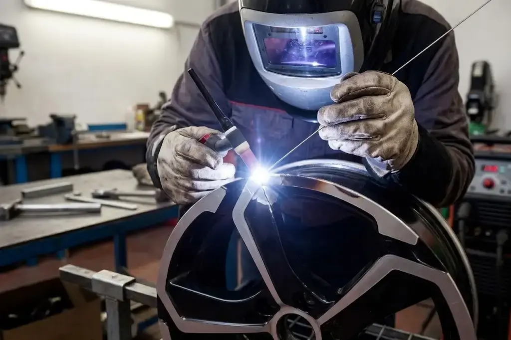 Technician TIG welding a cracked alloy wheel at the Larkhall workshop