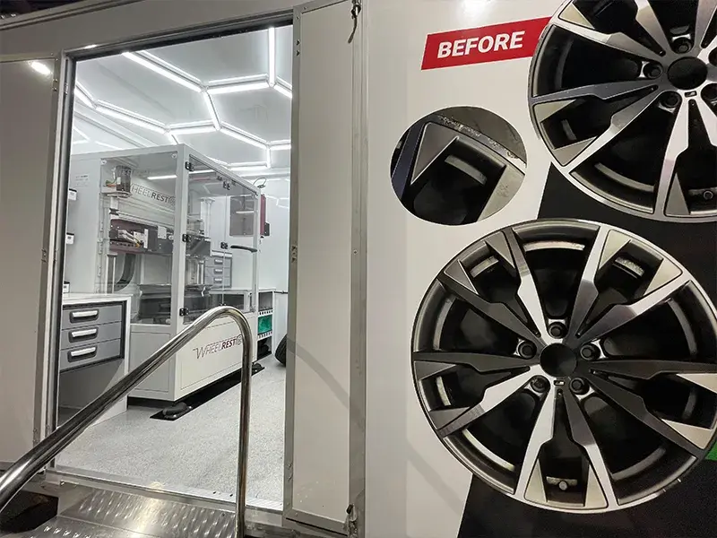 Technician working on a wheel in the refinishing bay