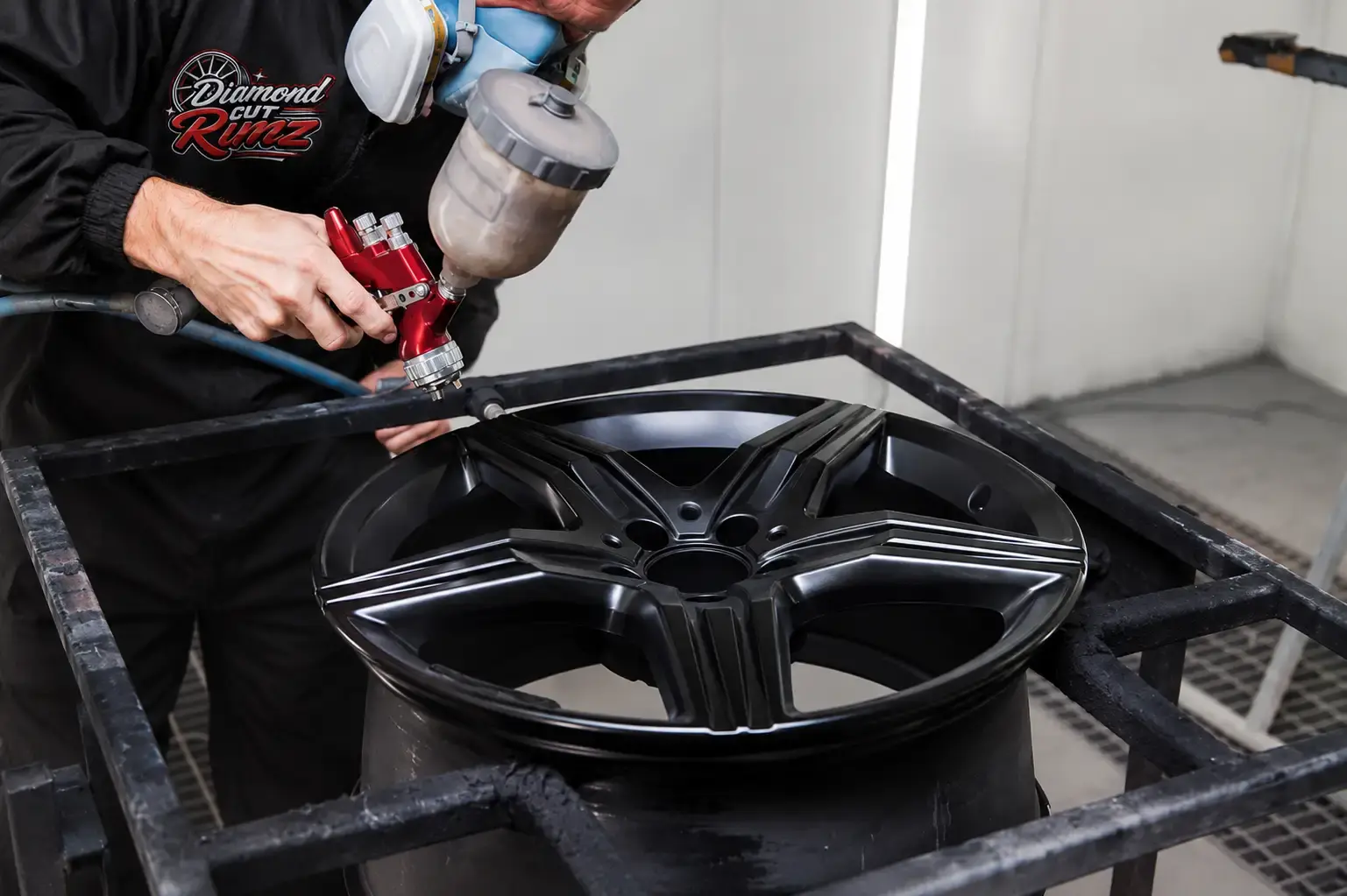 Alloy wheel being coated in the spray booth before oven curing